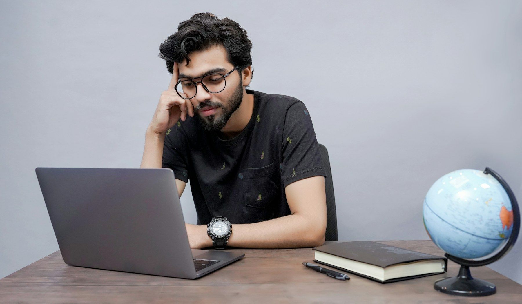 A professional working through a problem at his laptop