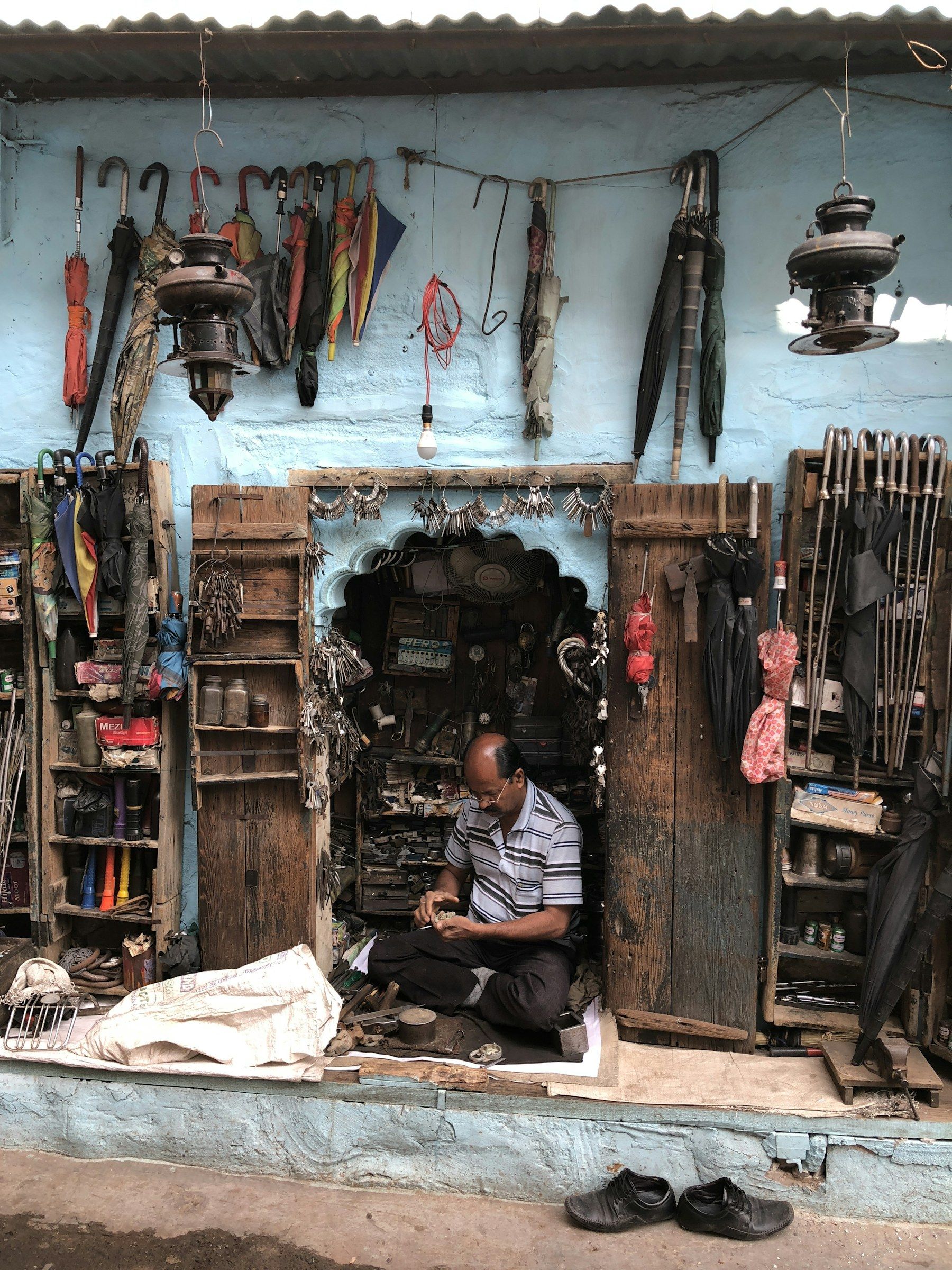 A shopkeeper at work in the doorway of a small shop