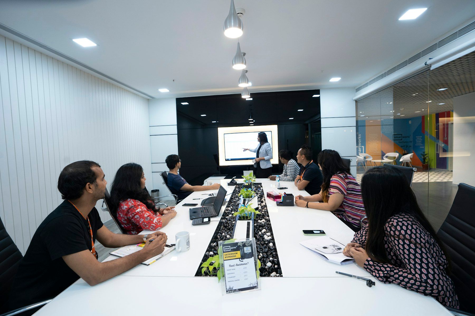 A team workshop in a bright meeting room, a presenter at the front